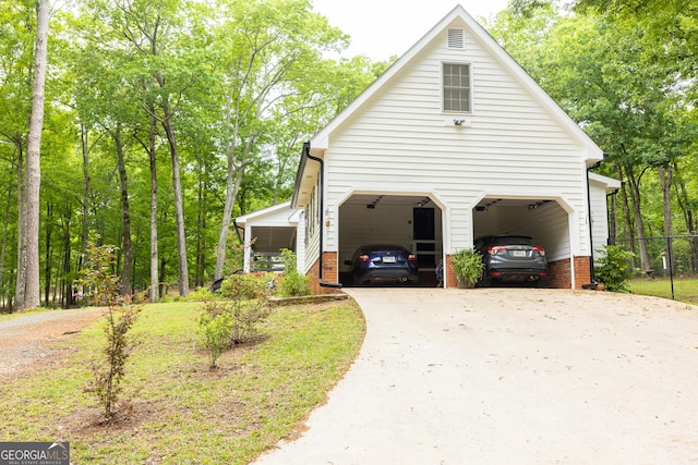 view of side of property featuring fence, driveway, and a garage