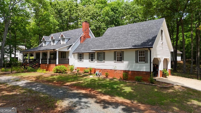 cape cod-style house with a porch, driveway, a chimney, roof with shingles, and a garage
