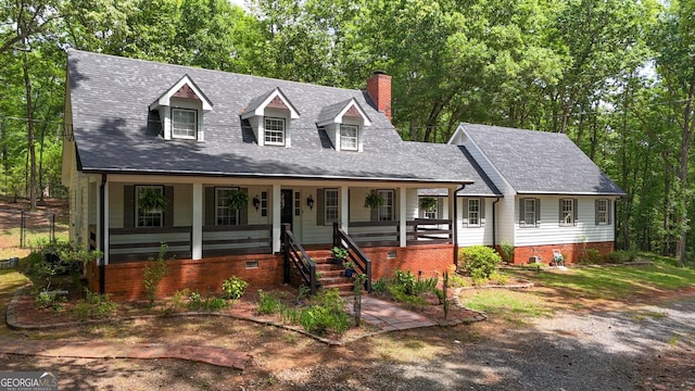 cape cod home featuring a porch, a chimney, and a shingled roof