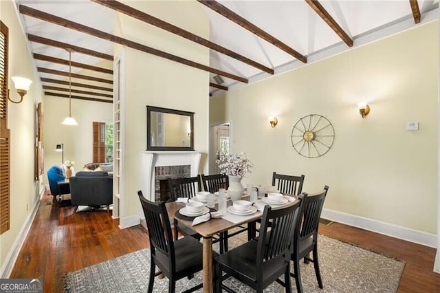 dining space with a brick fireplace, high vaulted ceiling, hardwood / wood-style floors, a healthy amount of sunlight, and beamed ceiling
