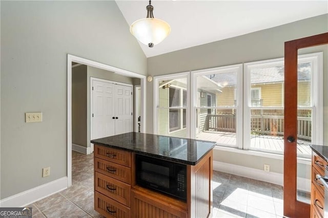 kitchen featuring black microwave, light tile patterned floors, baseboards, lofted ceiling, and dark stone counters