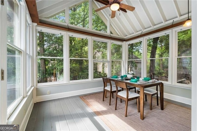 sunroom / solarium featuring baseboards, a wooden deck, hardwood / wood-style flooring, and lofted ceiling