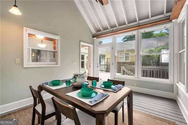 sunroom / solarium featuring baseboards, wood finished floors, high vaulted ceiling, and beamed ceiling