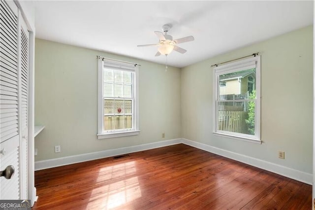 unfurnished room with baseboards, a ceiling fan, and wood finished floors