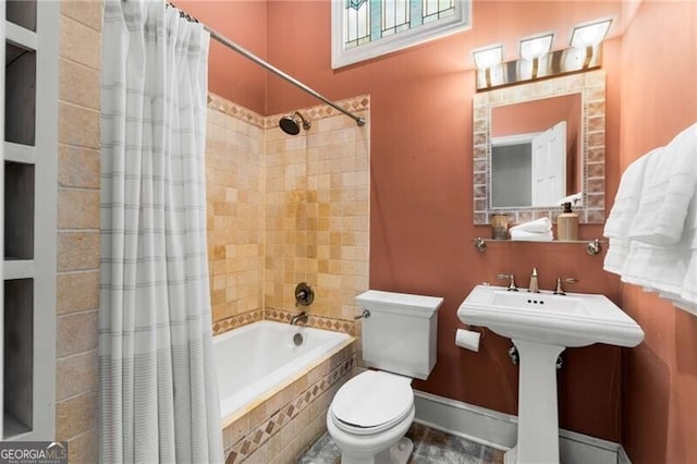 bathroom featuring tiled shower / bath and toilet