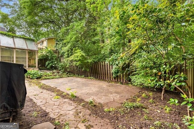 view of yard featuring an outdoor structure, a fenced backyard, an exterior structure, and a patio area