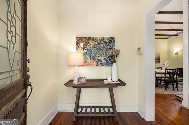 entryway featuring baseboards, beamed ceiling, and wood finished floors