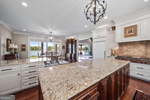 kitchen featuring recessed lighting, an inviting chandelier, stainless steel gas stovetop, light stone counters, and white cabinetry