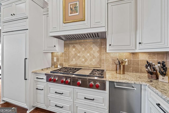 kitchen featuring tasteful backsplash, white cabinets, dark wood-style flooring, light stone countertops, and stainless steel gas cooktop