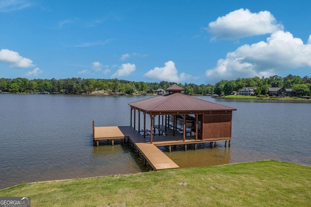 view of dock featuring a lawn and a water view