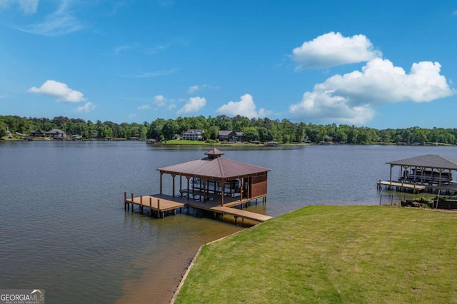 dock area with boat lift, a lawn, a water view, and a gazebo