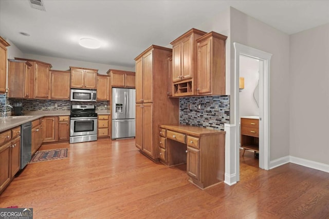 2995 Boulder Walk Ct SE, Atlanta, GA 30316 - kitchen featuring appliances with stainless steel finishes, light wood-type flooring, backsplash, light countertops, and a sink