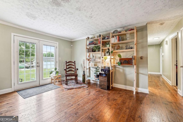 sitting room with attic access, hardwood / wood-style flooring, baseboards, a textured ceiling, and french doors