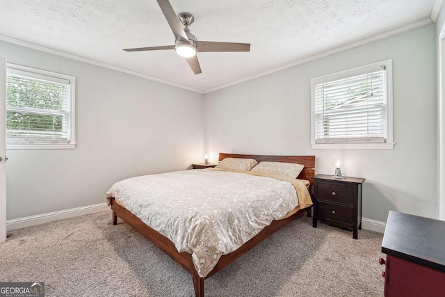 carpeted bedroom featuring baseboards, a ceiling fan, and crown molding
