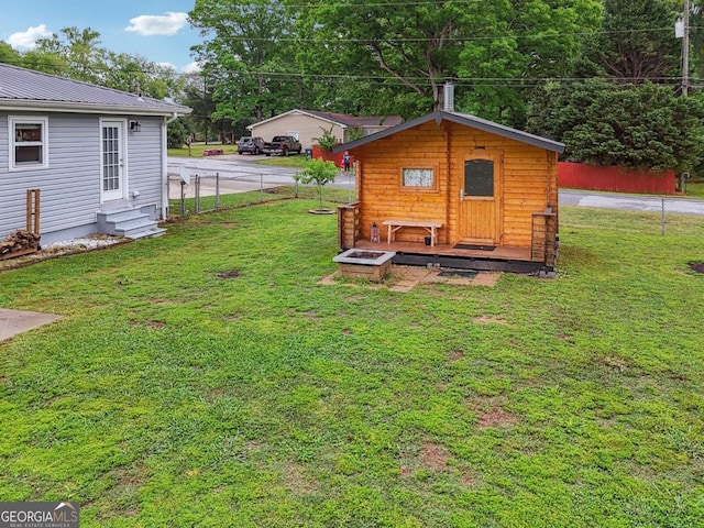 view of yard featuring fence, entry steps, and an outbuilding