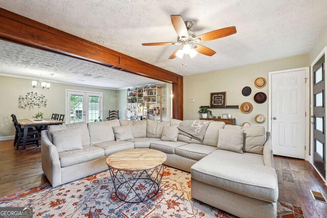 living area with wood-type flooring, a textured ceiling, and visible vents