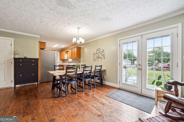 dining area featuring crown molding, dark wood-style floors, french doors, and a chandelier
