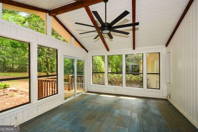 unfurnished sunroom with beamed ceiling, a ceiling fan, and plenty of natural light