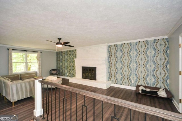 living room with wood finished floors, ceiling fan, a textured ceiling, and crown molding