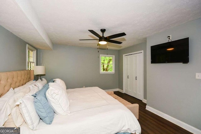 bedroom with baseboards, wood finished floors, a ceiling fan, and a closet