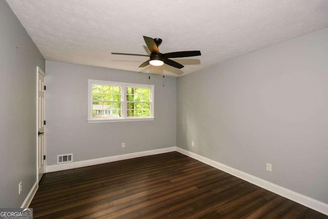 unfurnished room with ceiling fan, baseboards, visible vents, a textured ceiling, and dark wood-type flooring