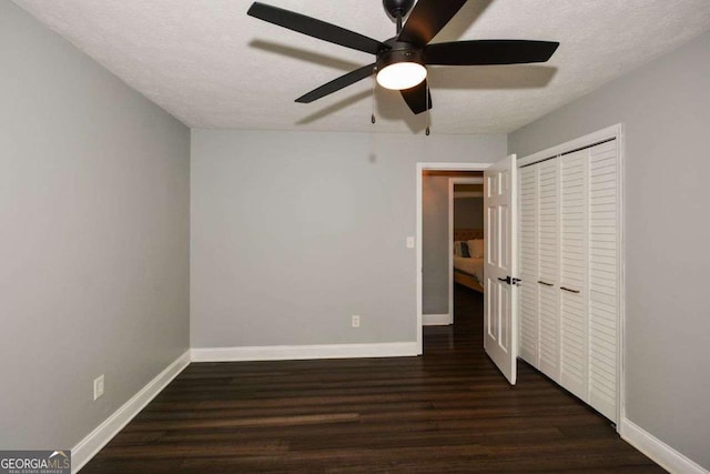 unfurnished bedroom with a closet, wood finished floors, and baseboards