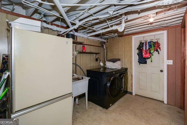 clothes washing area with wooden walls, laundry area, and washing machine and clothes dryer