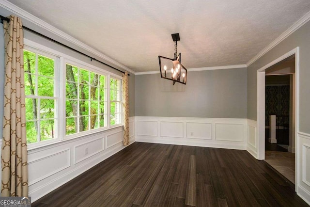 unfurnished dining area with dark wood-style flooring, a chandelier, a wainscoted wall, and ornamental molding