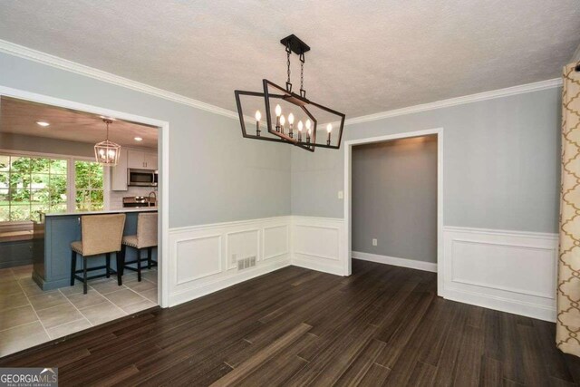 unfurnished dining area with an inviting chandelier, wood finished floors, and visible vents