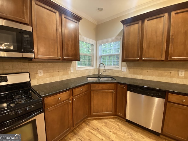 71 Anita Pl SE, Mableton, GA 30126 - kitchen with stainless steel appliances, dark stone counters, light wood-style floors, ornamental molding, and tasteful backsplash