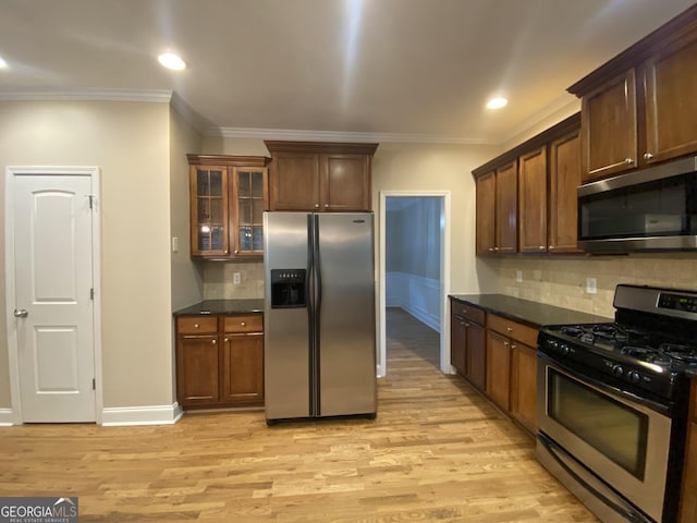 71 Anita Pl SE, Mableton, GA 30126 - kitchen featuring appliances with stainless steel finishes, ornamental molding, dark countertops, light wood finished floors, and decorative backsplash