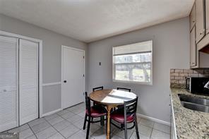 1824 Guardian Way, Lawrenceville, GA 30043 - dining room with a fireplace, light tile patterned flooring, and baseboards