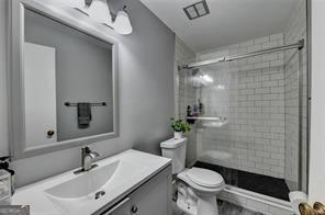 1824 Guardian Way, Lawrenceville, GA 30043 - bathroom featuring toilet, a tile shower, and vanity