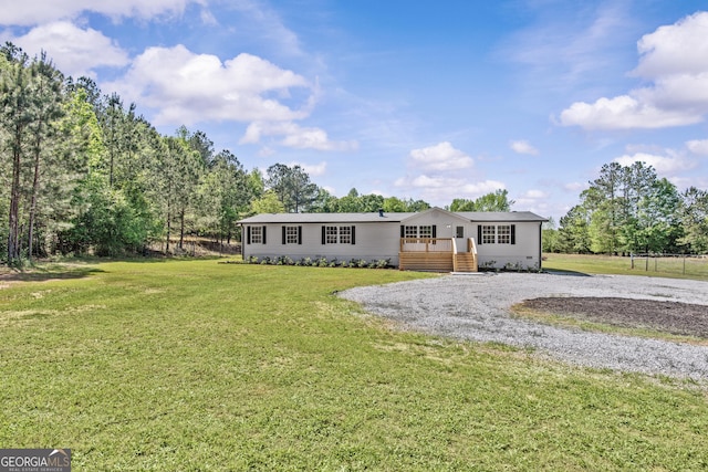 view of front of house featuring a front lawn and gravel driveway