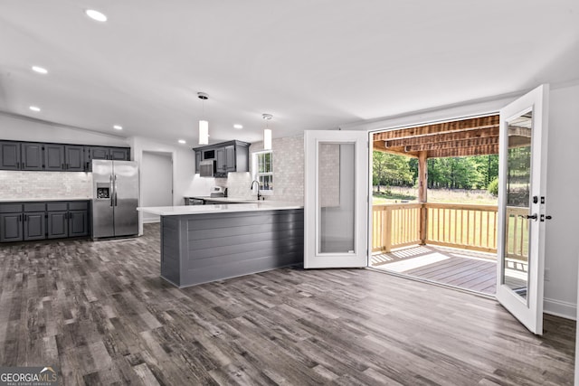 kitchen with gray cabinetry, stainless steel appliances, decorative backsplash, and a sink