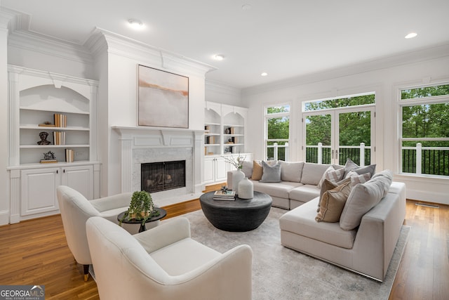 8345 Jett Ferry Rd, Sandy Springs, GA 30350 - living area featuring wood finished floors, ornamental molding, built in features, a high end fireplace, and recessed lighting