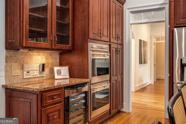 8345 Jett Ferry Rd, Sandy Springs, GA 30350 - kitchen featuring wine cooler, stainless steel appliances, tasteful backsplash, light wood-type flooring, and stone countertops