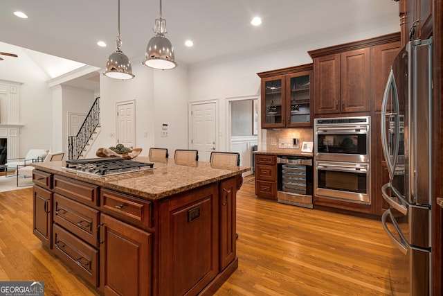 8345 Jett Ferry Rd, Sandy Springs, GA 30350 - kitchen featuring appliances with stainless steel finishes, beverage cooler, light wood-style floors, a kitchen island, and backsplash
