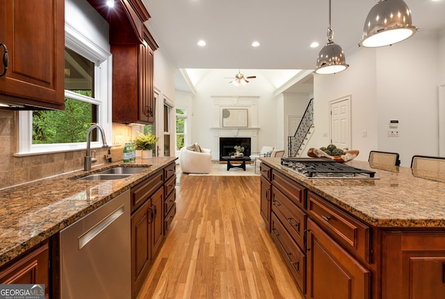 8345 Jett Ferry Rd, Sandy Springs, GA 30350 - kitchen with appliances with stainless steel finishes, a fireplace, light wood-style floors, a ceiling fan, and stone counters