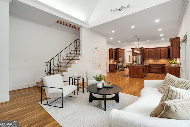 8345 Jett Ferry Rd, Sandy Springs, GA 30350 - living room with recessed lighting, crown molding, light wood finished floors, stairway, and vaulted ceiling
