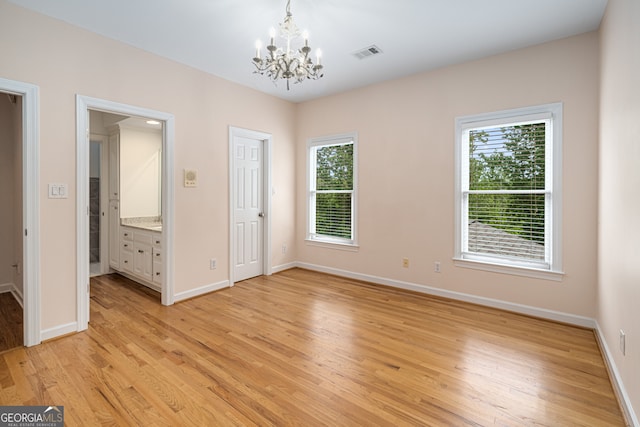 8345 Jett Ferry Rd, Sandy Springs, GA 30350 - unfurnished room with a chandelier, plenty of natural light, and light wood finished floors