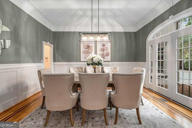 8345 Jett Ferry Rd, Sandy Springs, GA 30350 - dining room featuring a chandelier, wood finished floors, wainscoting, ornamental molding, and a decorative wall