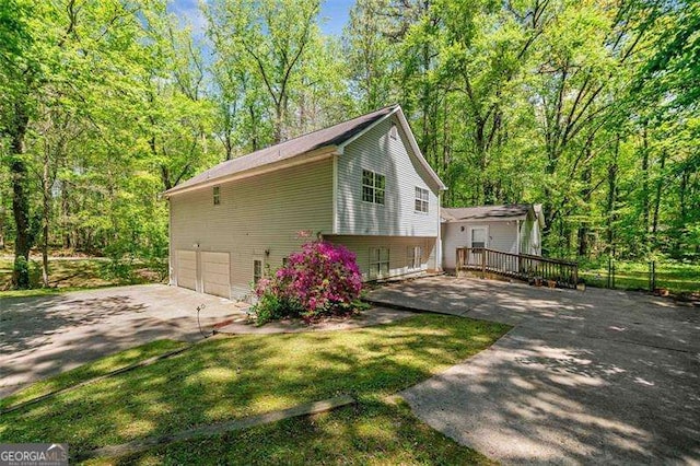 3420 Honeysuckle Ln, Lithia Springs, GA 30122 - view of property exterior featuring a garage, a wooden deck, and driveway