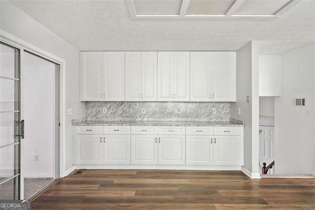 3420 Honeysuckle Ln, Lithia Springs, GA 30122 - kitchen featuring dark wood finished floors, white cabinets, and backsplash