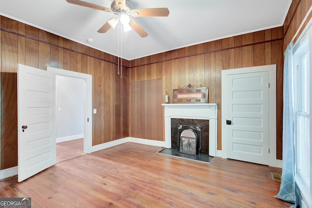 48 Roseview Dr, Concord, GA 30206 - unfurnished living room featuring a ceiling fan, visible vents, wood walls, a high end fireplace, and wood finished floors