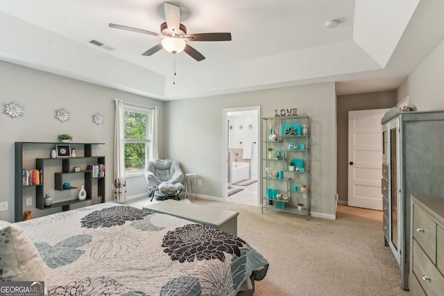 bedroom with visible vents, baseboards, light carpet, and a tray ceiling