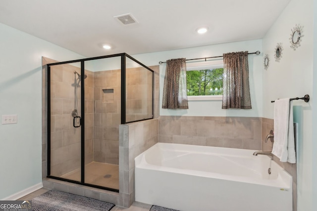 bathroom featuring visible vents, a shower stall, a garden tub, and recessed lighting
