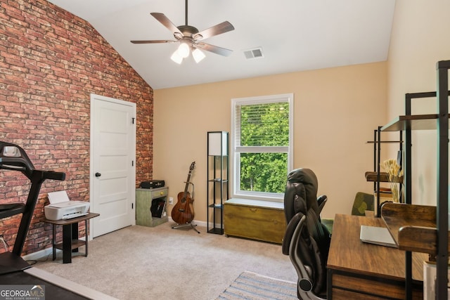 carpeted home office featuring brick wall, vaulted ceiling, ceiling fan, baseboards, and visible vents
