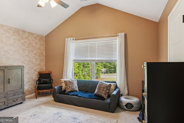 sitting room with a ceiling fan, wallpapered walls, vaulted ceiling, and carpet