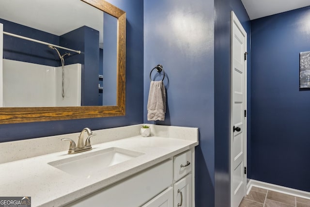 bathroom with tile patterned floors, a shower, vanity, and baseboards